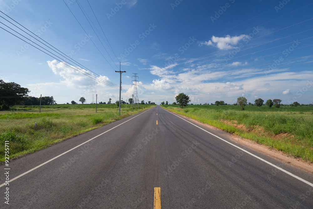 asphalt road through the green field