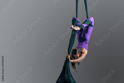 Sporty woman doing exercise with elastics, aerial silk ribbons. Sport training gym and lifestyle concept. Anti-gravity yoga.