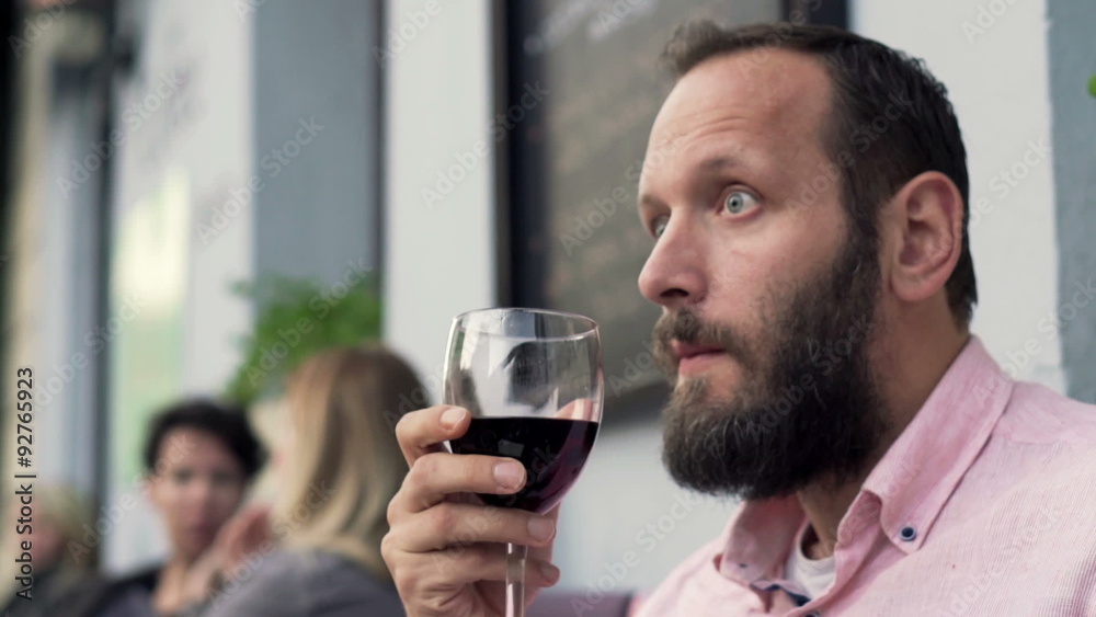 Young pensive man drinking red wine in cafe in the city
Young pensive man drinking red wine in cafe in the city