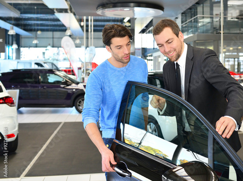 Verkaufsgespräch im Autohaus - Verkäufer berät Kunden beim Kauf eines Neuwagen // sales talk in the car trade  photo