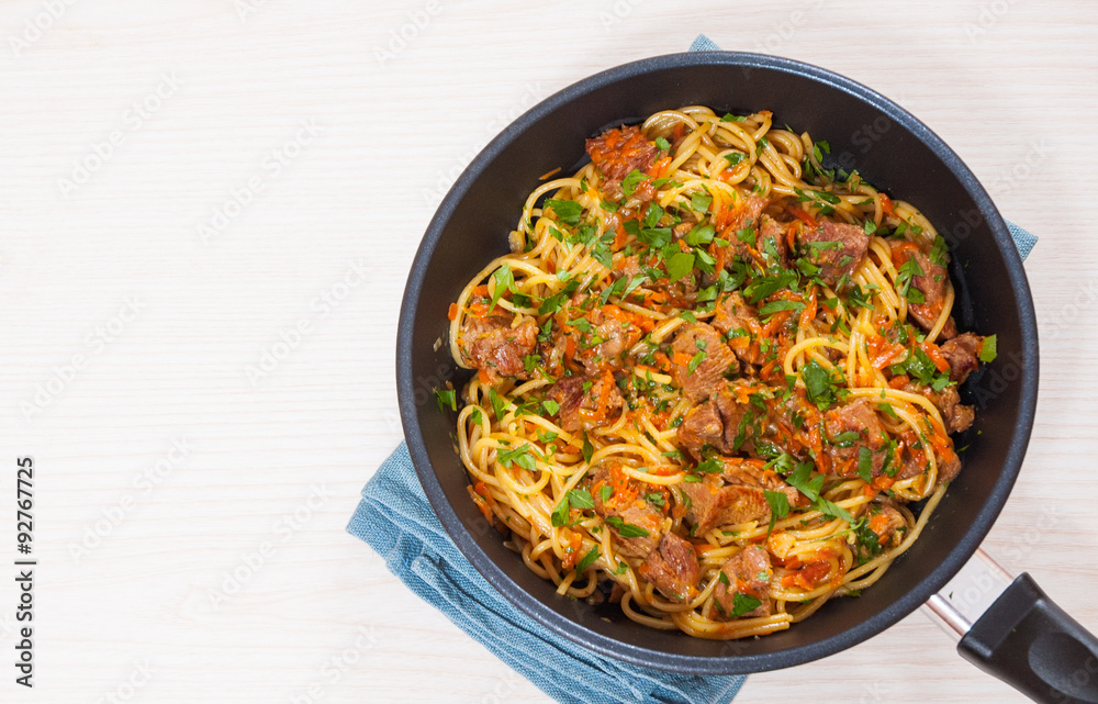 Pieces of meat and vegetables with spaghetti in a frying pan Pieces of meat and vegetables with spaghetti in a frying pan
