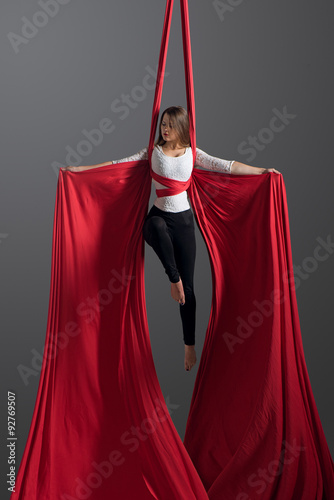 Sporty woman doing exercise with elastics, aerial silk ribbons. Sport training gym and lifestyle concept. Anti-gravity yoga.