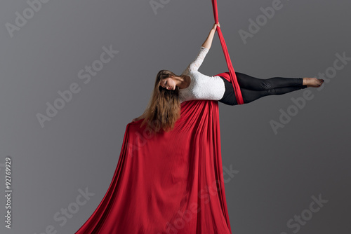 Sporty woman doing exercise with elastics, aerial silk ribbons. Sport training gym and lifestyle concept. Anti-gravity yoga.