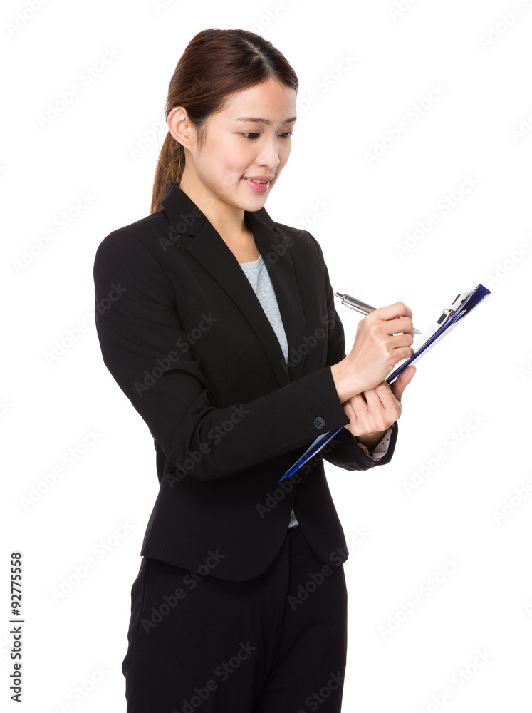 Asian businesswoman take note on clipboard Asian businesswoman take note on clipboard