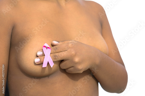 Mujer africana con una cinta rosa en la mano sobre el pecho desnudo contra el cáncer de mama photo
