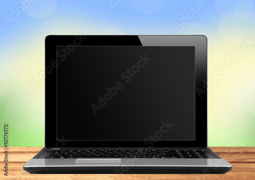 Black laptop on wooden table