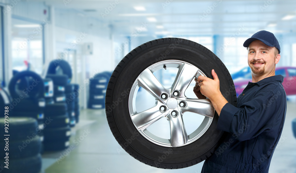 Car mechanic with a tire . Car mechanic with a tire .