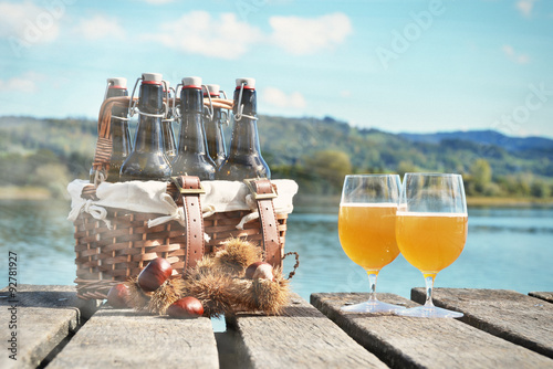 Beer on the wooden jetty against a lake photo