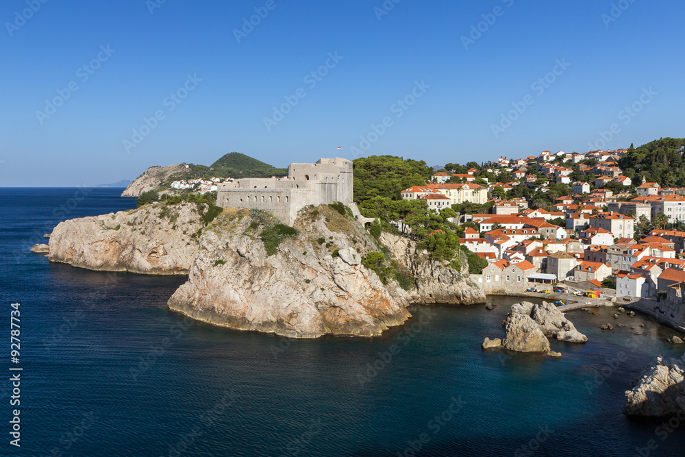 View of Fort Lovrijenac (St. Lawrence Fortress) on a steep cliff and old residential buildings by the bay in Dubrovnik, Croatia.