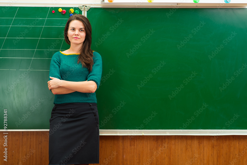 teacher in classroom near blackboard