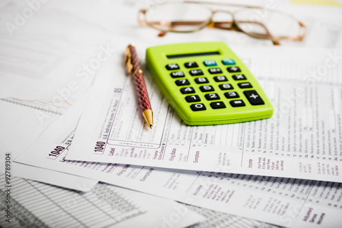 Calculating numbers for income tax return with pen, glasses and