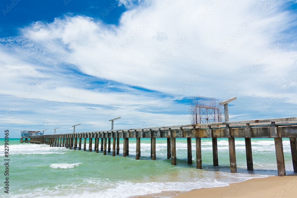 Long bridge on the beach with blue sky