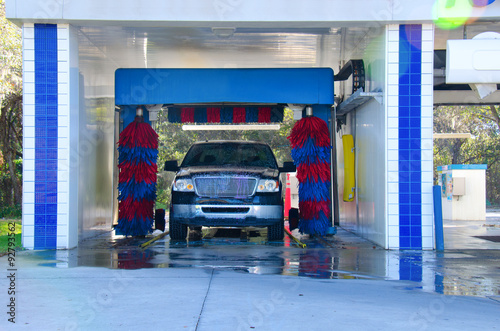 An automated car wash facility with a soapy truck in the process of getting washed