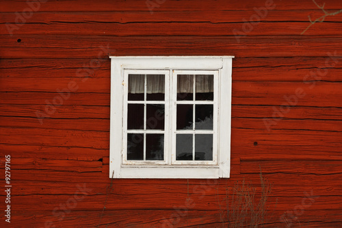 Old-fashioned cottage painted in swedish traditional red color.