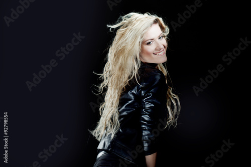 Beautiful and smiling young blonde girl, black background