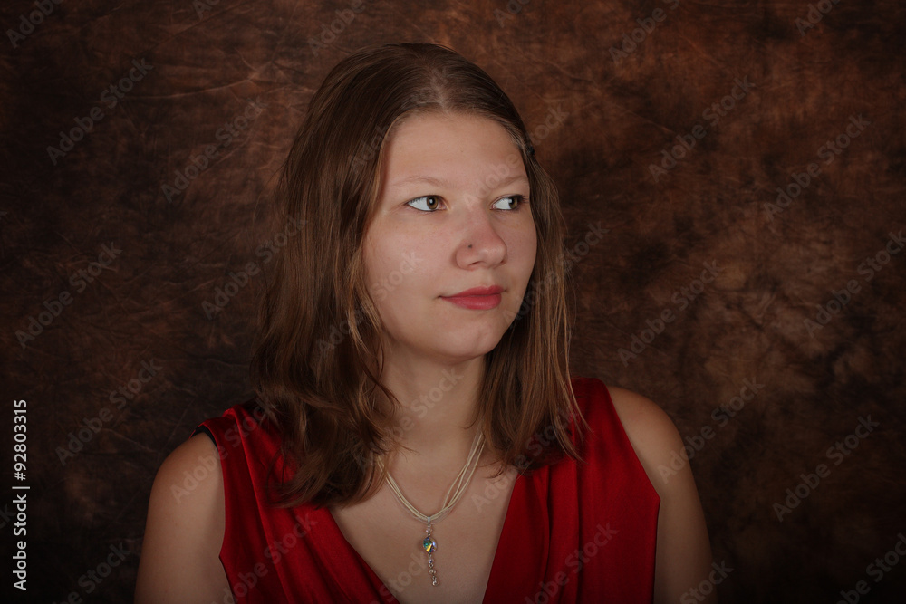 Fototapeta premium Portrait of young woman on brown batik background