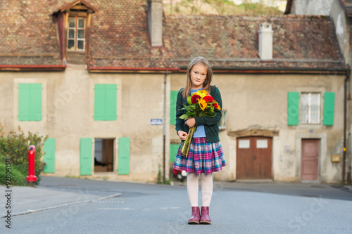 Outdoor portrait of a cute little girl with beautiful bouquet of flowers © annanahabed