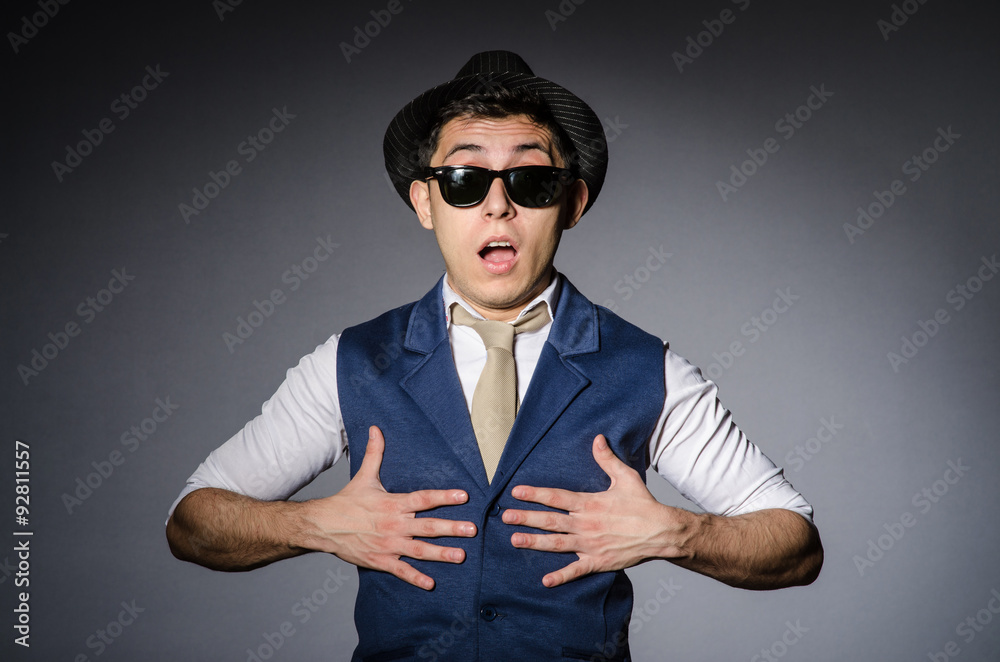 Young man in blue vest and hat against gray Young man in blue vest and hat against gray