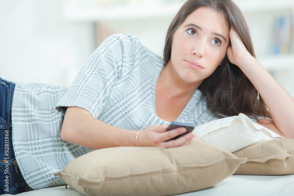 Sending a text message whilst laying on a sofa Sending a text message whilst laying on a sofa