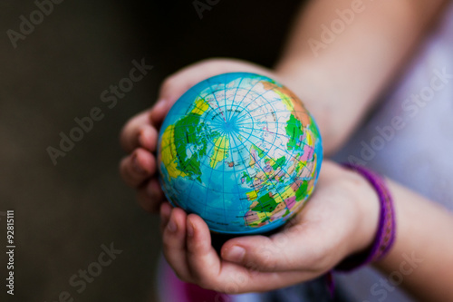 Little girl holding the earth in her hands. Earth day. Green concept