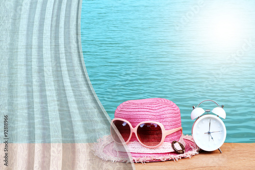 white drapery on clock and hat wearing sunglasses with lake back
