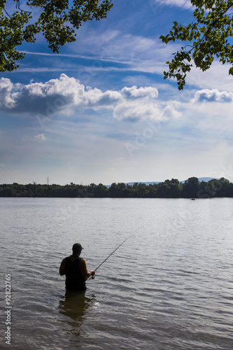 fisher fishing on sunshine in water danube