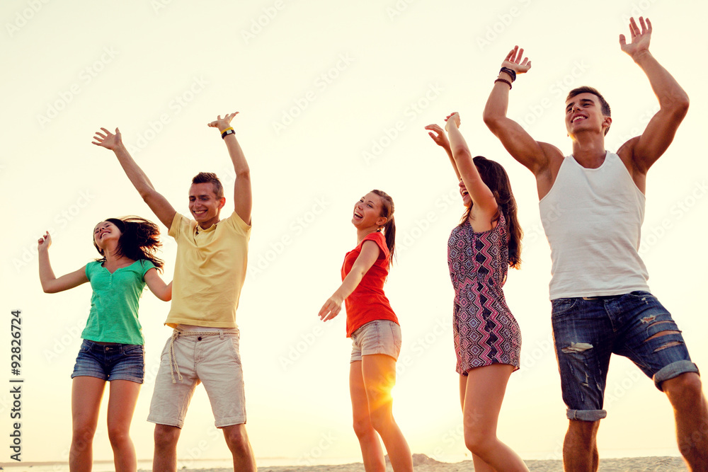 Fototapeta premium smiling friends dancing on summer beach