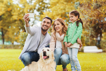 happy family with dog taking selfie by smartphone
