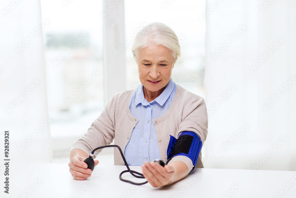 old woman with tonometer checking blood pressure old woman with tonometer checking blood pressure
