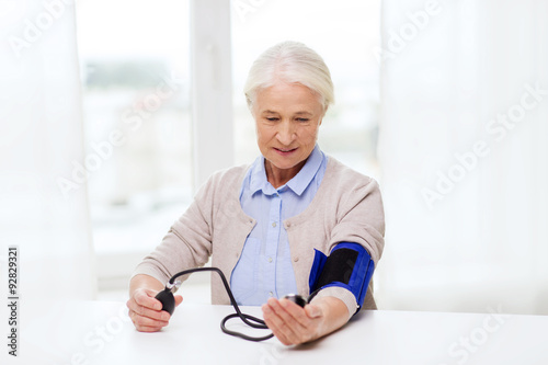 old woman with tonometer checking blood pressure