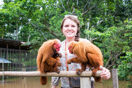 Woman and Bald Uakari Monkeys photo