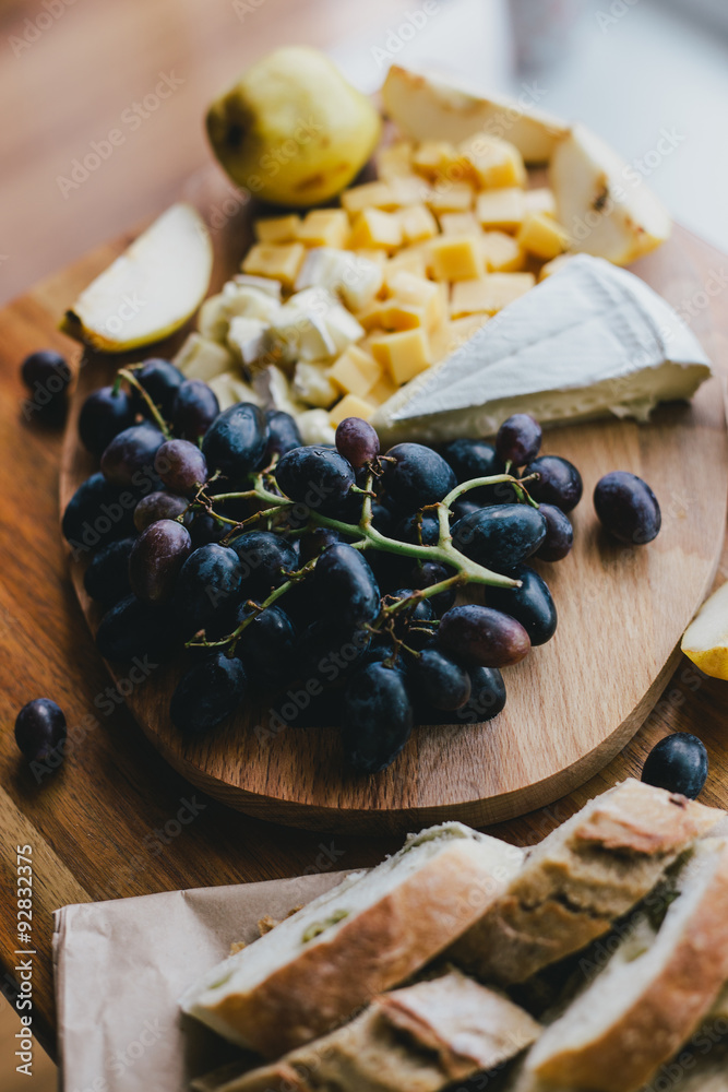 Table with wine, cheese, bread, grapes and pears standing on a cozy balcony Table with wine, cheese, bread, grapes and pears standing on a cozy balcony
