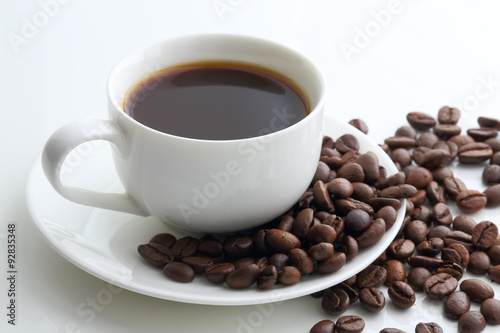 cup of coffee and coffee beans on a white