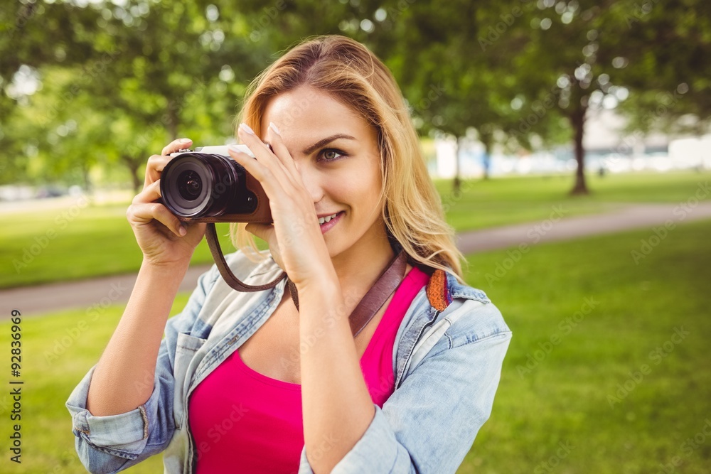 Smiling woman taking picture with camera 
