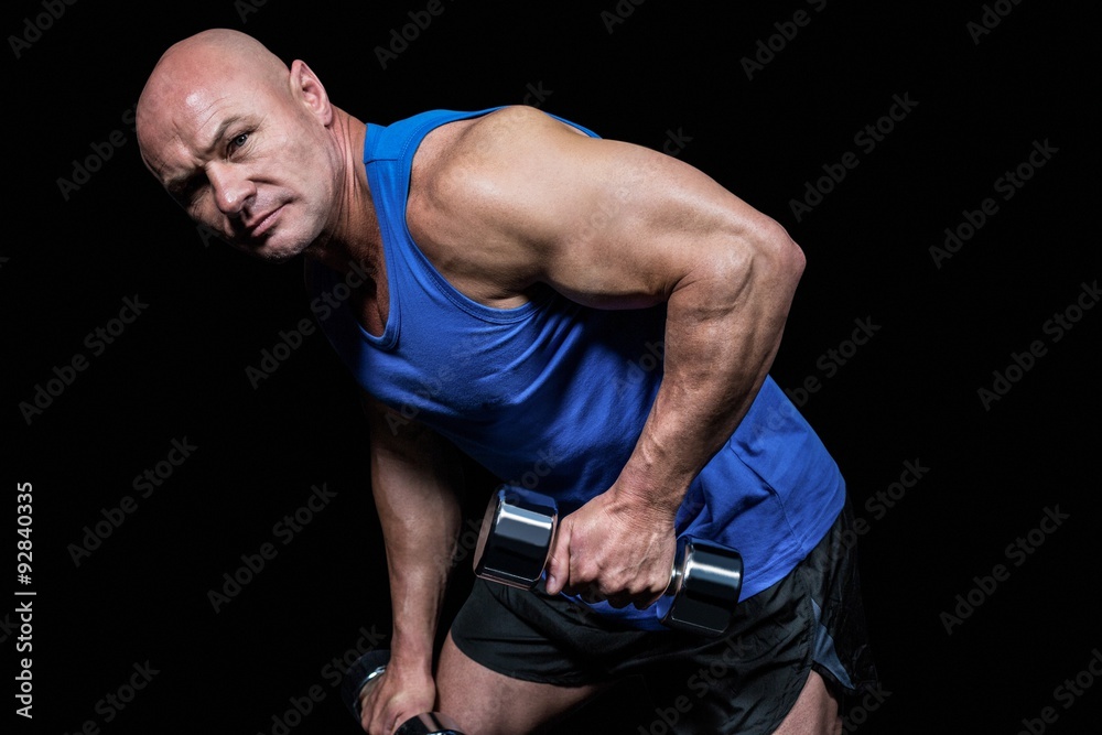 Portrait of fit man exercising with dumbbells