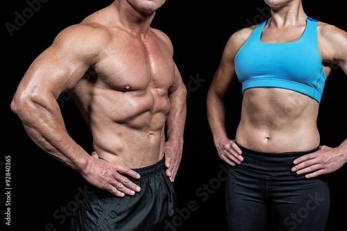 Midsection of muscular man and woman with hands on hip © WavebreakmediaMicro