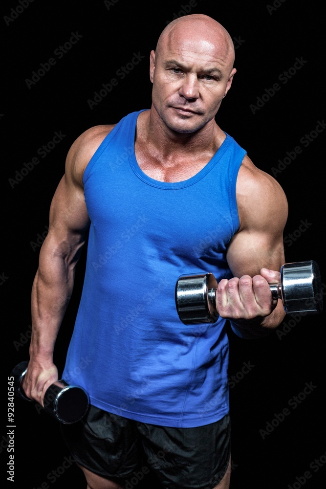 Portrait of man lifting dumbbells
