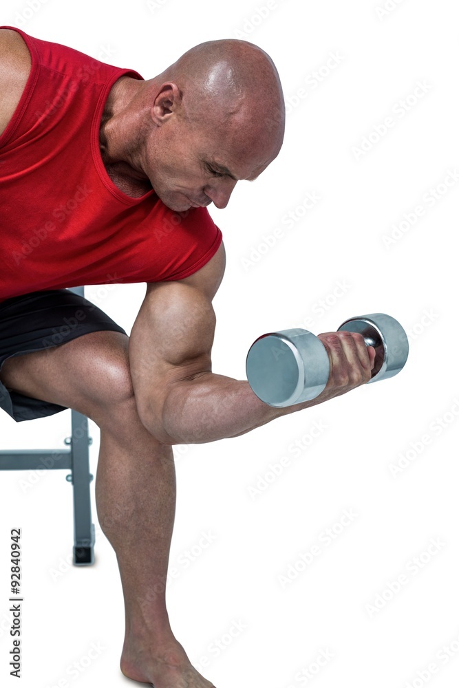 Naklejka premium Bald man exercising by lifting dumbbells