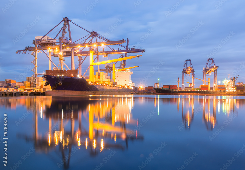 Containers loading by crane at dark sunset