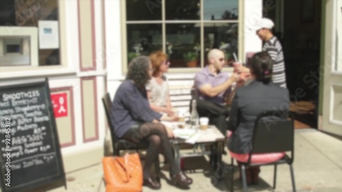 People sitting outside a small cafe on sidewalk photo