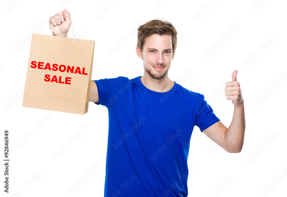 Man with shopping bag and thumb up and showing phrase of seasona Man with shopping bag and thumb up and showing phrase of seasona