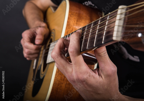 Hands of a young guy who plays guitar.