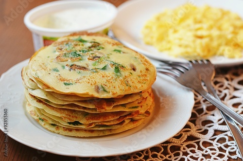 Pancakes with herbs and mushrooms and scrambled eggs for breakfast
