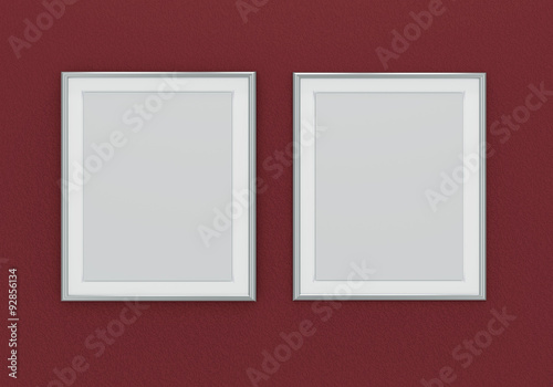 Picture of two silver picture frames over dark red wall
