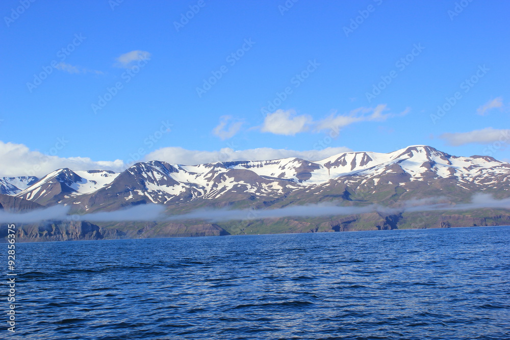 Mit Schnee bedeckte Berge entlang der Küste an der Bucht von Akureyri (Island)
