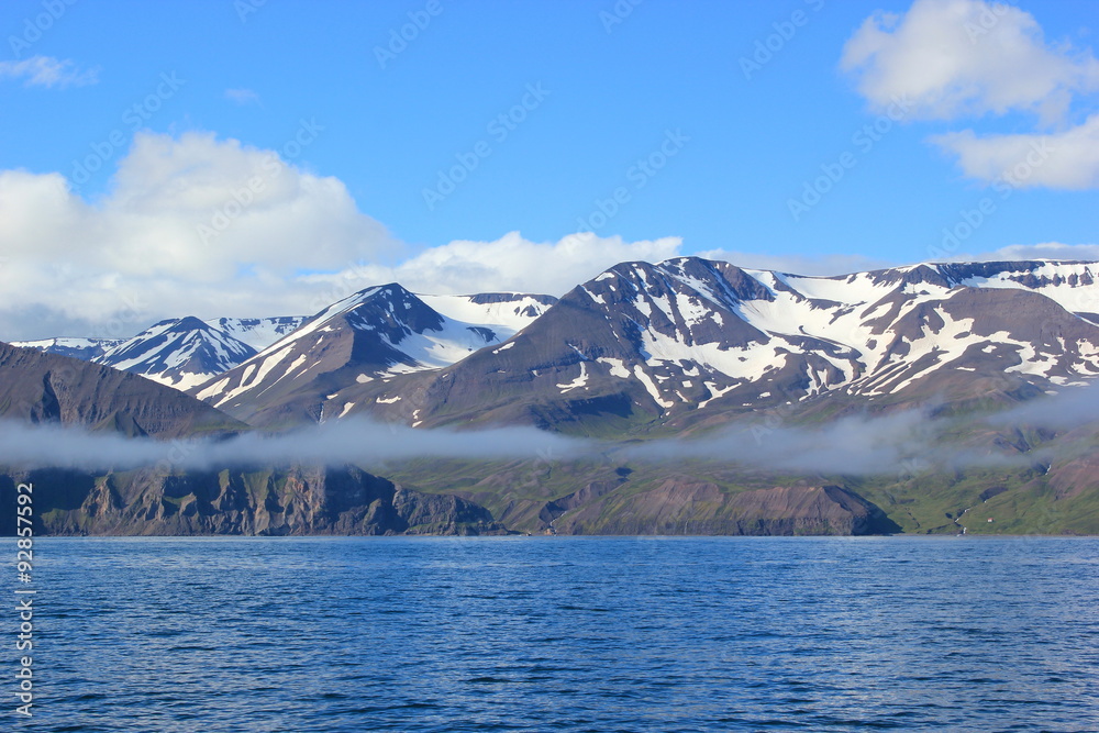 Blick auf die mit Schnee bedeckten Berg entlang der Bucht von Akureyri auf Island