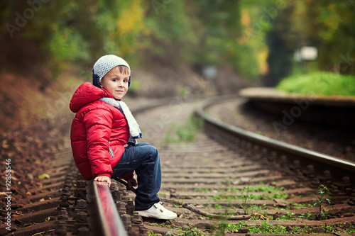 Cute boy walking on a railroad