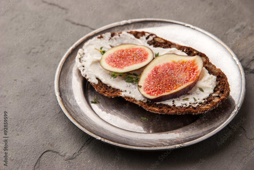 Bread with fresh cheese , fig and thyme on the vintage metal plate Bread with fresh cheese , fig and thyme on the vintage metal plate