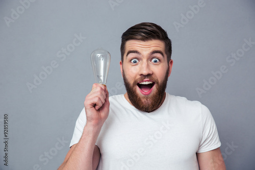 Portrait of a cheerful man holding bulb