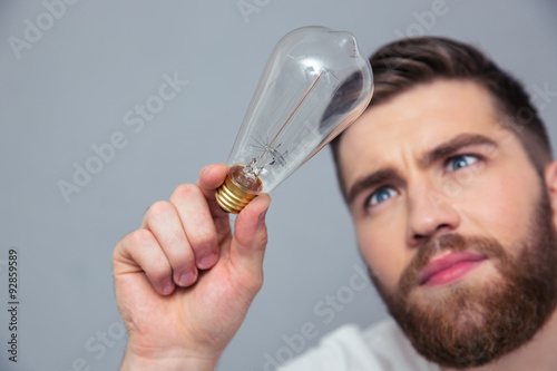 Handsome man looking on bulb